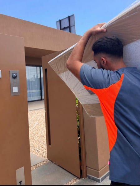 Miembro del equipo entrando un cabecero embalado en una vivienda