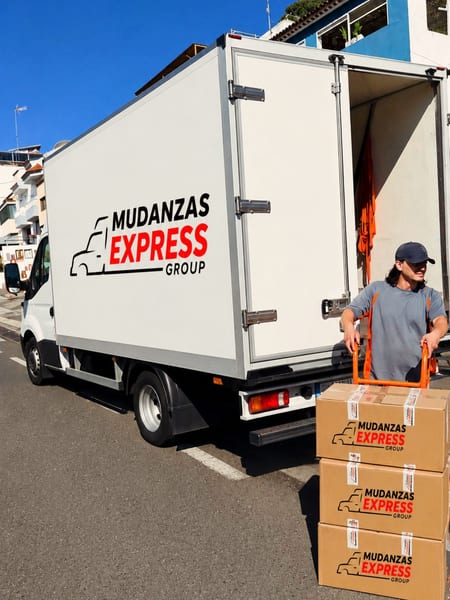 Camión de Mudanzas Express Group con cajas de la empresa apiladas en la calle